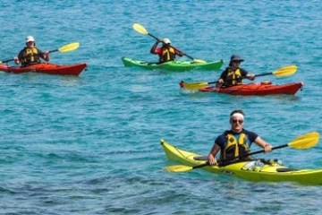 a group of people riding on the back of a boat in the water
