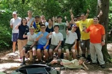 a group of people standing next to a tree