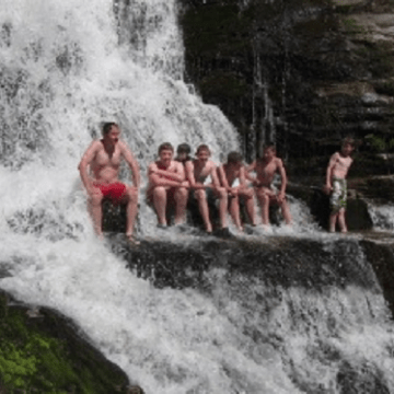 a group of people riding on the back of a waterfall