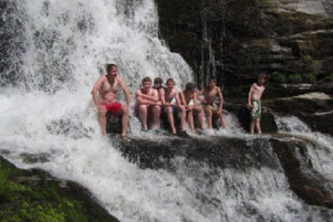 a group of people riding on the back of a waterfall