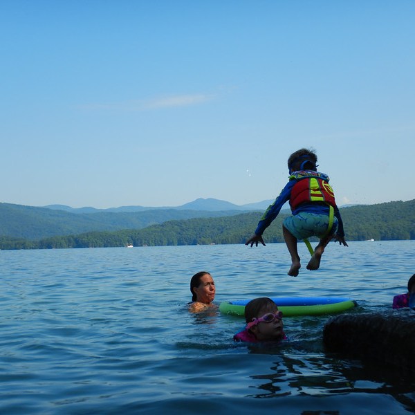 a man riding on the back of a boat in the water