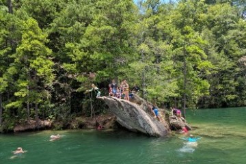 a group of people riding on the back of a boat in the water