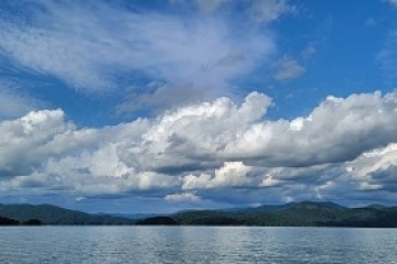 a group of clouds in the sky over a body of water