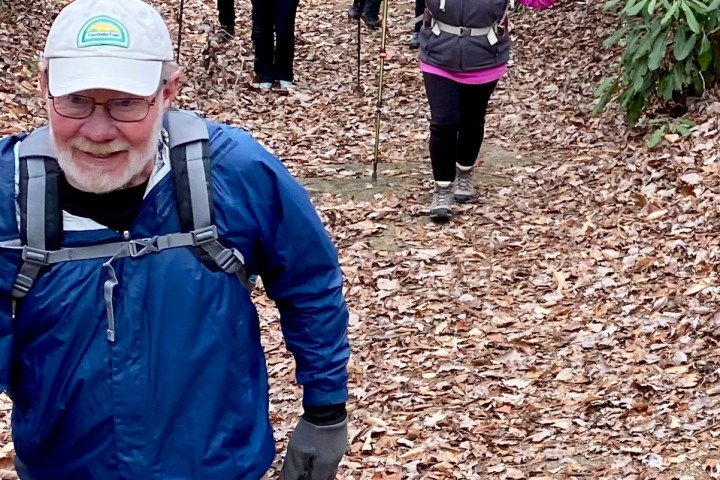 a man standing next to a forest