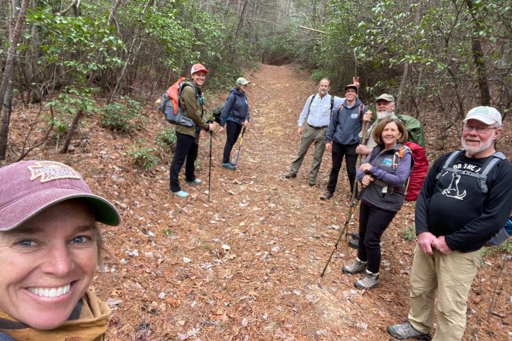 a group of people standing next to a tree
