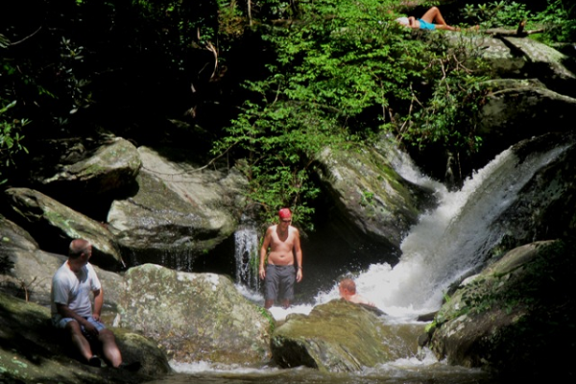 a man standing next to a waterfall