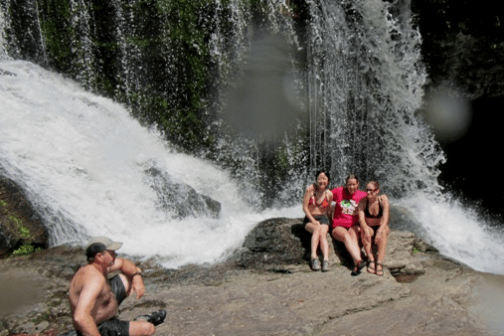 a group of people standing next to a waterfall
