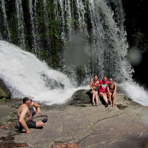 a group of people standing next to a waterfall