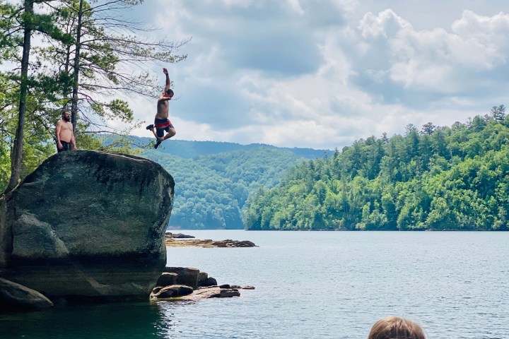 a group of people sitting next to a body of water