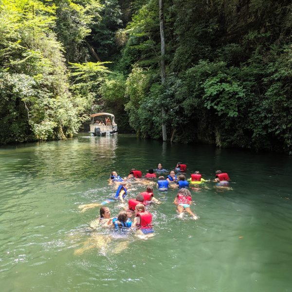 a group of people riding on the back of a boat in the water