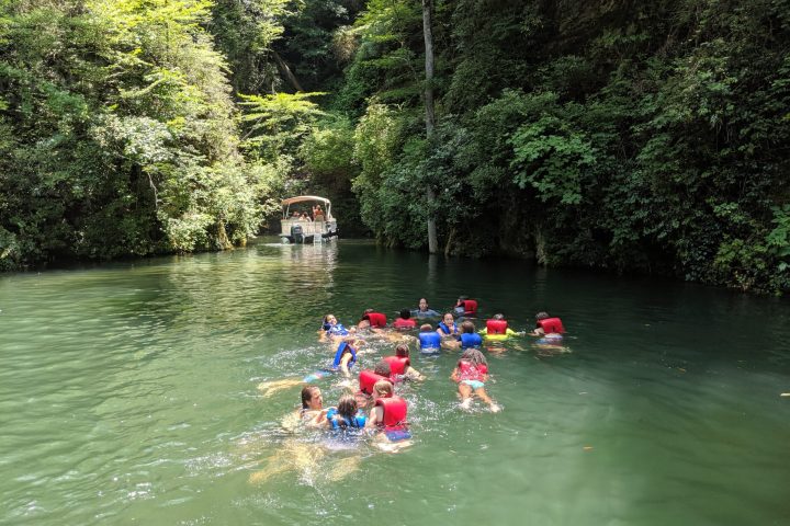 a group of people riding on the back of a boat in the water