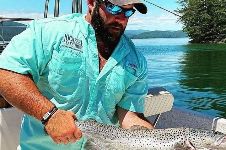 a man holding a fish on a boat