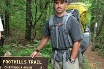 a man standing next to a forest