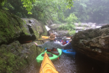 a waterfall with trees on the side of a river