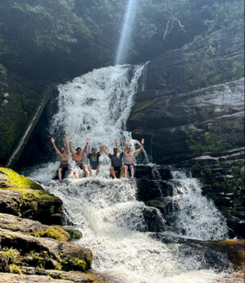 a man standing next to a waterfall