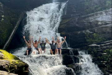 a man standing next to a waterfall