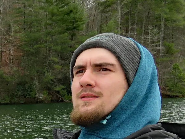 a man standing next to a body of water