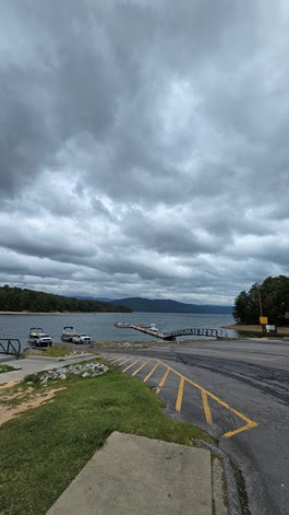 a body of water with trees on the side of a road