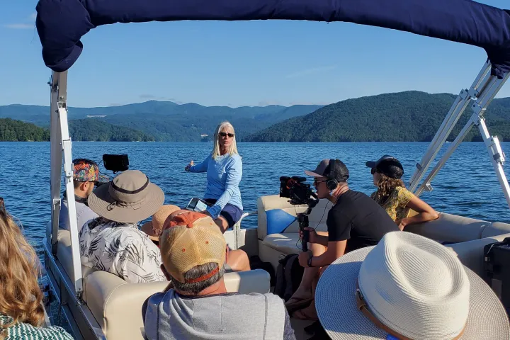 a group of people sitting in a boat on a body of water