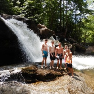 a man standing next to a waterfall