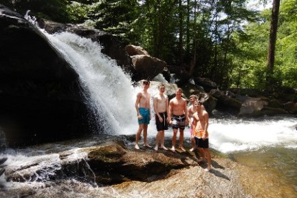 a man standing next to a waterfall