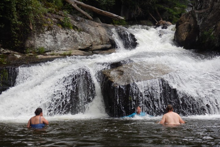 a group of people riding on the back of a waterfall