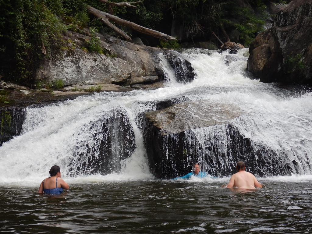 a group of people riding on the back of a waterfall