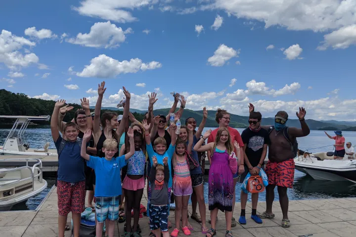 a group of people standing on a beach posing for the camera