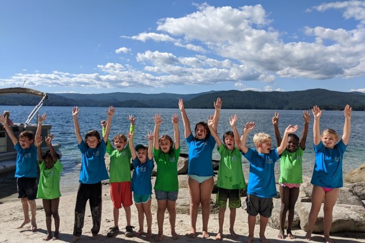 a group of people standing on a beach posing for the camera