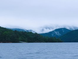 a large body of water with a mountain in the background
