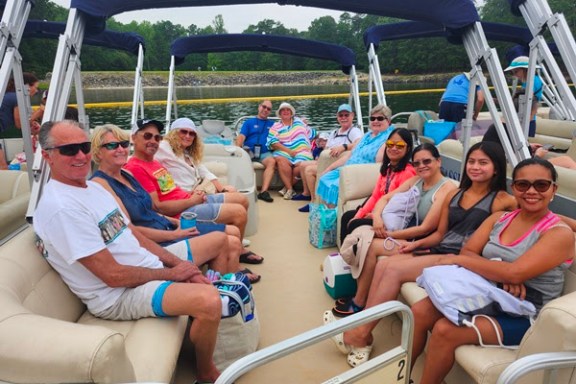 Group of people sitting on a boat enjoying a sunny day on the water.