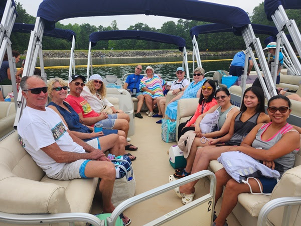 Group of people sitting on a boat enjoying a sunny day on the water.